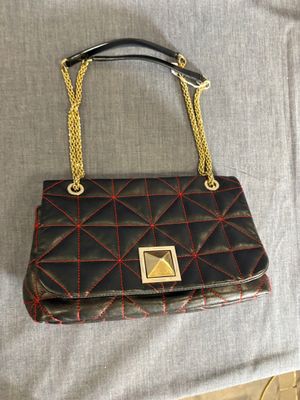un sac à main noir et rouge avec une chaîne dorée