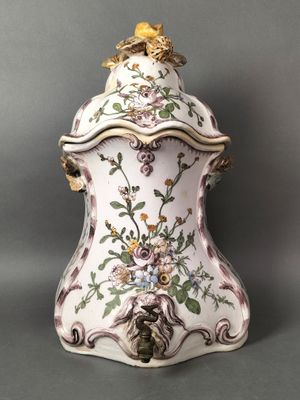 un vase richement décoré, surmonté d'un oiseau