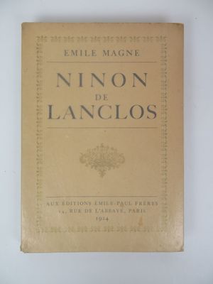 an old book sitting on top of a table next to a white wall