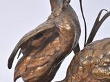 a bronze statue of two birds on a table