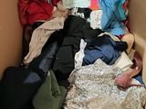 a cardboard box filled with clothes and clothing on the floor