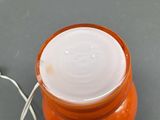 a jar of cream sitting on a table next to a wire