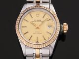 une photo d'une montre Rolex pour femme posée sur une surface noire