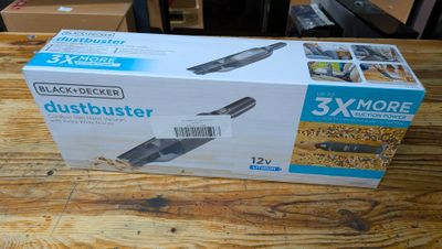 une boîte contenant un aspirateur Dustbuster de la marque Black & Decker posée sur une table