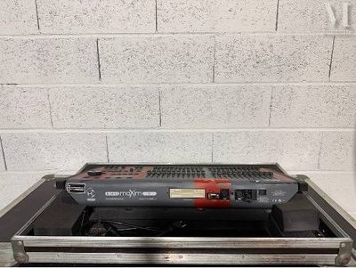 a laptop sitting on top of a case in front of a brick wall