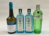 trois bouteilles d'alcool sont alignées sur une surface blanche
