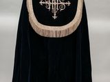 une image représentant une cape noire ornée d'une croix
