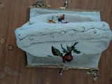 a white purse with a flower on it on a wooden floor