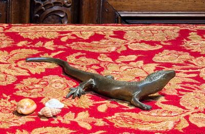 une statue de lézard posée sur une nappe rouge