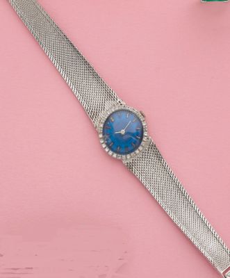 une image représentant une montre-bracelet au cadran bleu sur un fond rose