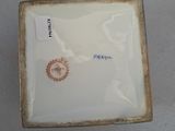 a small square plate with a picture of a bird on it