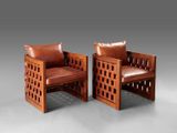 two wooden chairs with leather cushions and a brown leather cushion