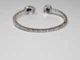 a close up of a diamond bracelet on a white surface