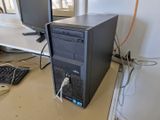 un ordinateur de bureau posé sur un bureau, à côté d'un clavier