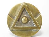une image représentant une plaque en laiton ornée d'un motif pyramidal