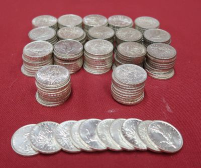 a pile of silver coins sitting on a red surface