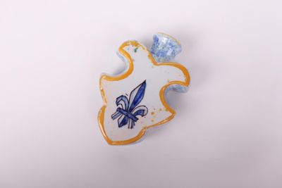 a blue and white pin with a blue flower on it