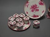 a table with a plate, cups and saucers on it