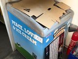 a box of ice cream sitting on top of a refrigerator