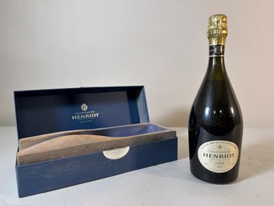 La bouteille de champagne se trouve à côté d'une boîte contenant une cuillère en bois.