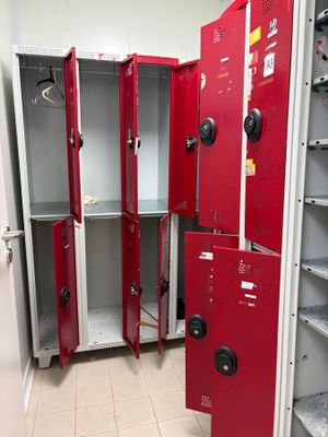 many red lockers in a room with white tile flooring