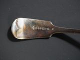 a silver spoon with a spoon handle on a black surface