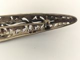 a silver broochee that is on a white surface