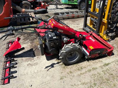 un tracteur rouge qui est garé dans la terre