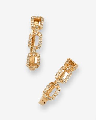 une paire de boucles d'oreilles en or serties de diamants sur fond blanc