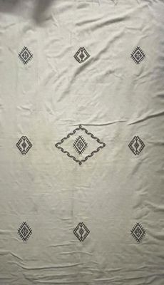 une photo d'un lit recouvert d'une couverture blanche et noire