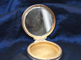 a small compact mirror sitting on a blue cloth