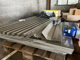 several pieces of metal are stacked on pallets in a warehouse