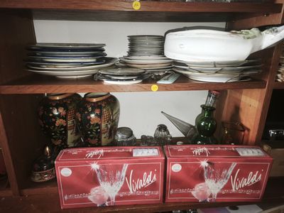 many plates and bowls on a shelf in the kitchen