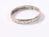 a close up of a silver ring on a white surface