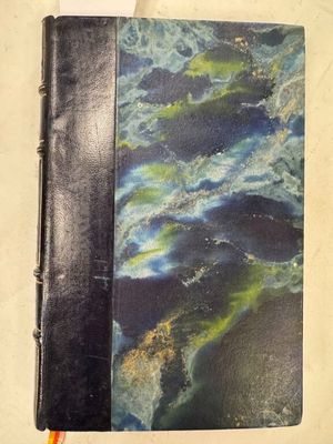 un cahier noir à la couverture bleue et un crayon jaune