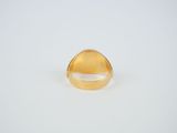 a close up of a gold ring on a white surface
