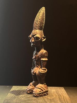 statue d'un homme coiffé d'un chapeau, posée sur une table en bois