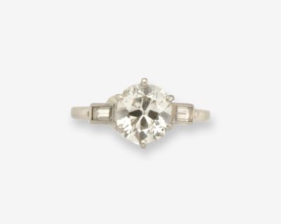 une bague sertie d'un diamant unique, agrémentée de diamants taille baguette et de montures latérales