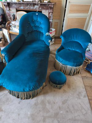 un fauteuil bleu et un repose-pieds dans un salon