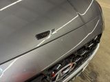 a close up of a car ' s grille with a number plate on it