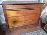 une commode en bois posée sur un parquet