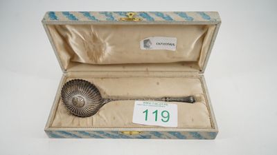 a silver spoon in a box with a price tag on it