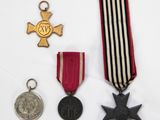 three medals and a medal are on a white surface