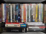 de nombreux DVD rangés dans un boîtier en plastique noir sur une étagère