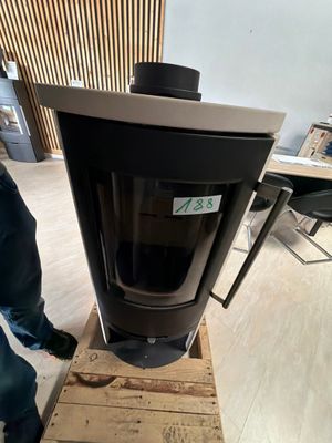 a man standing next to a black stove in a room