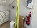 a yellow coat rack in the corner of a room