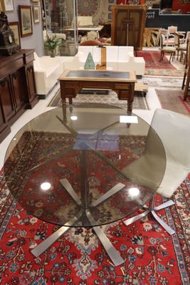 une photo d'un salon avec une table en verre et des chaises