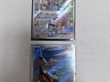 two pokemon cards sitting on top of each other on a table