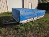 a trailer with a tarp on it in the grass