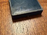a small black book sitting on a wooden table